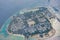 Maldives local island aerial view. Houses and port with boats surrounding with blue sea