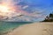 Maldives. Sunshine through clouds light the beach with palm trees