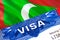 Maldives Visa in passport. USA immigration Visa for Maldives citizens focusing on word VISA. Travel Maldives visa in national