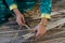 Maldivian girl stitches dry palm leaves with big needle