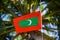 Maldivian red green colour national flag on the rope during beautiful windy day