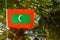 Maldivian red green colour national flag on the rope during windy day