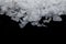 Maldon salt on black background macrophotography with slight defocus.
