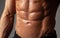 Male abdominal muscles closeup with sweat drops after exercise