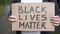 Male activist holds a cardboard with the words black lives matter.