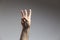male adult hand showing number Two gesture in studio shot isolated on grey background