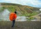 Male adult hiker adventurer hiking with heavy backpack back standing outdoor looking at steaming ground in Laugaveur trek in