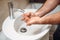 male adult washing hands at home using disinfectant and gel, tap water and cleaning cosmetics