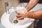 Male adult washing hands at home using disinfectant and gel, warm tap water and cleaning cosmetics