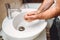 male adult washing hands at home using disinfectant and soap, tap water and cleaning cosmetics