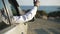 Male African American hand sticking out of car window at background of picturesque turquoise Mediterranean sea