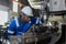 Male African American workers wearing uniform safety and hardhat working an iron cutting machine in factory Industrial.