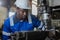 Male African American workers wearing uniform safety and hardhat working an iron cutting machine in factory Industrial.