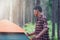 Male African-Asian tourist setting up the tent at the forest.