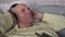 Male aged person in headset lying down on home sofa and listening music.