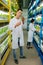 Male agriculturist wearing jeans and white coat planting greens