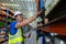 Male american african factory company employee scanning box checking number of products on goods shelves with tablet in warehouse