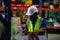 Male american african factory company employee scanning box checking number of products on goods shelves with tablet in warehouse