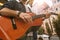 Male appealing guitarist playing music on street