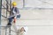 Male architect giving drill to female worker on scaffold at construction site