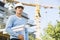 Male architect holding rolled up blueprints while standing at construction site