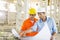 Male architects discussing over blueprint at construction site