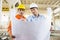 Male architects discussing over blueprint at construction site