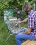 Male artist paint on plein air flowers pink peonies painting on nature