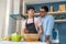 Male Asian LGBTQ couple enjoy each other company in their home kitchen while making homemade healthy salad