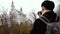 Male Asian tourist with backpack and camera standing and enjoying view of medieval Neuschwanstein castle