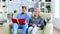 Male assistant in nursing home reading a book to retired elderly pensioner