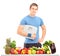 Male athlete holding a weight scale behind a table full of food