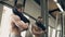 Male athlete puts on t-shirt standing in gym indoors.