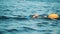 Male athlete swimming in a river with a tow float