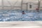 A male athlete swims in a swimming pool sports complex in blue water