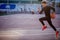 Male athlete wearing black sportwear running at track, side view