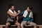 Male athletes resting and conversing at gym locker room