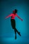 The male athletic ballet dancer performing dance on blue background. Studio shot. Ballet concept. Fit young man