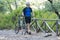 Male athletic cyclist walking with his bike