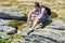 Male backpacker enjoying the mountain sitting on rock