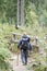 Male backpacker hiking in mountain forest with hike sticks. acti