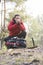 Male backpacker warming hands while looking away in forest