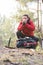 Male backpacker warming hands while looking away in forest