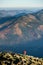 Male backpaker walking on the rocky top of the mountain