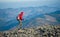 Male backpaker walking on the rocky top of the mountain