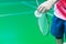 Male Badminton single player hand holds white shuttle together with racket, ready to serve position on play green court.