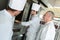 Male baker and assistants using oven