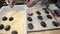 Male baker puts the raw dough on a baking sheet for baking