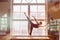 Male ballet dancer is dancing in front of a window