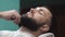 Male barber combing beard at a barber shop